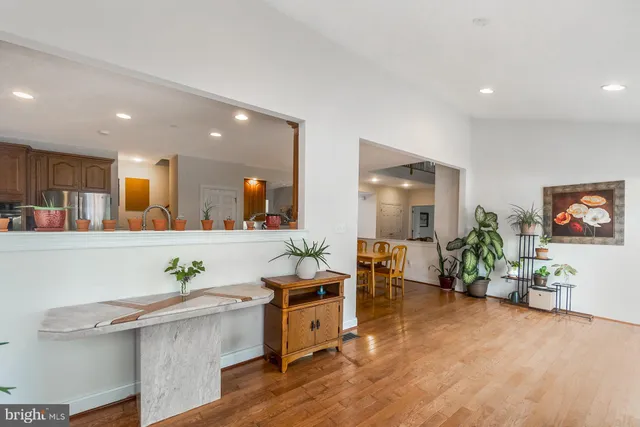 an empty room with wooden floor table and chairs