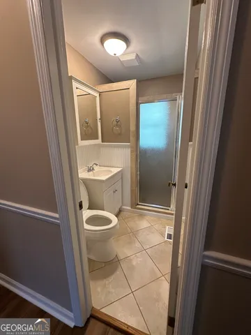 a bathroom with a toilet a sink and mirror
