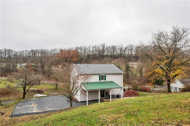 a view of a house with a yard and sitting area