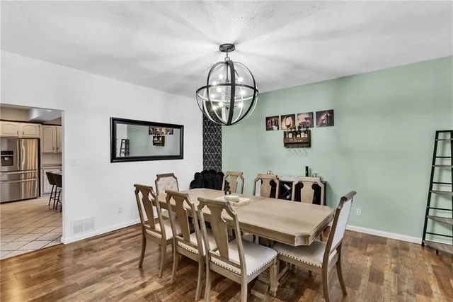 a view of a dining room with furniture wooden floor and a chandelier