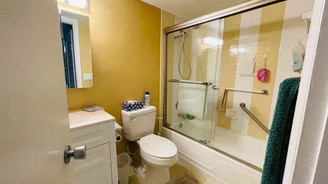 a bathroom with a granite countertop toilet and a shower