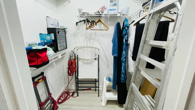 a view of walk in closet with clothes and shoes