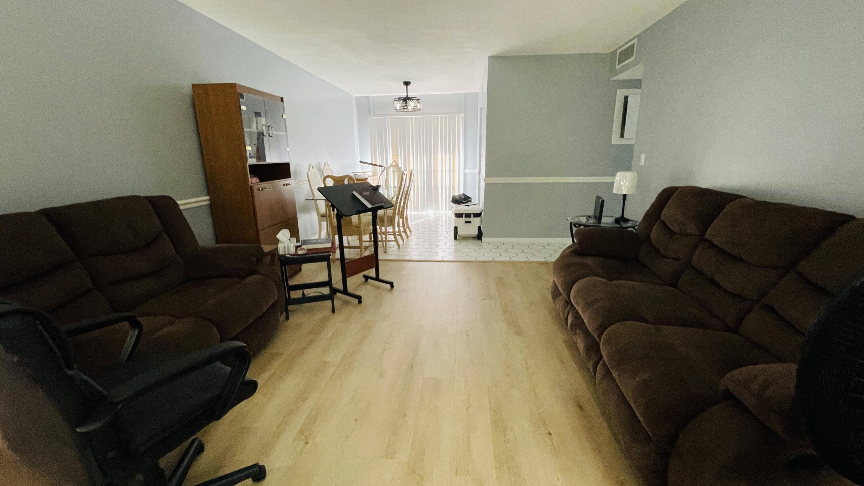 11 Golfs Edge, Unit E West Palm Beach, FL 33417 - Photo 2 of 14 a living room with furniture and a wooden floor