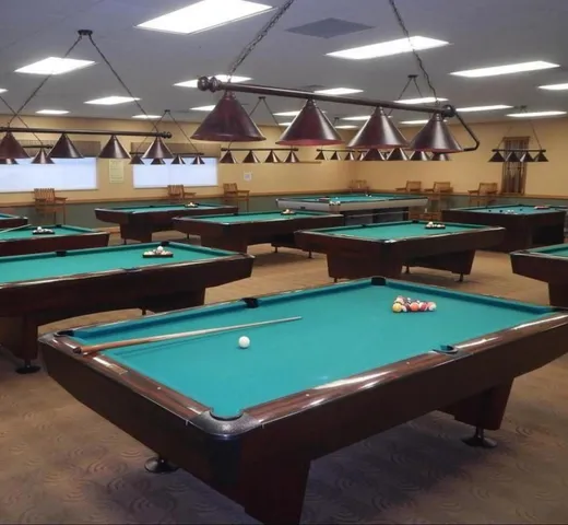 a room with pool table and wall paintings