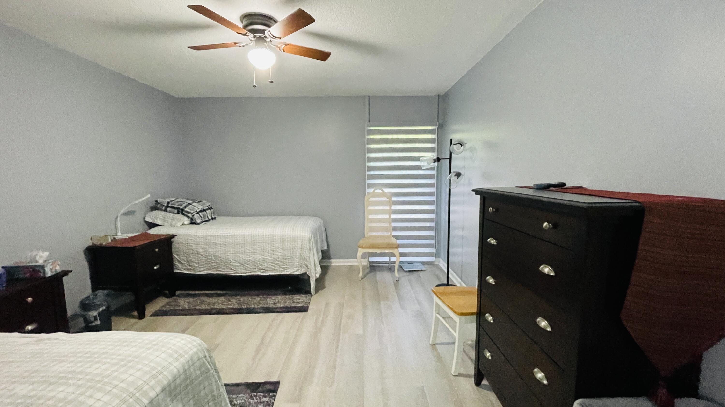 11 Golfs Edge, Unit E West Palm Beach, FL 33417 - Photo 8 of 14 a bedroom with a bed and wooden floor