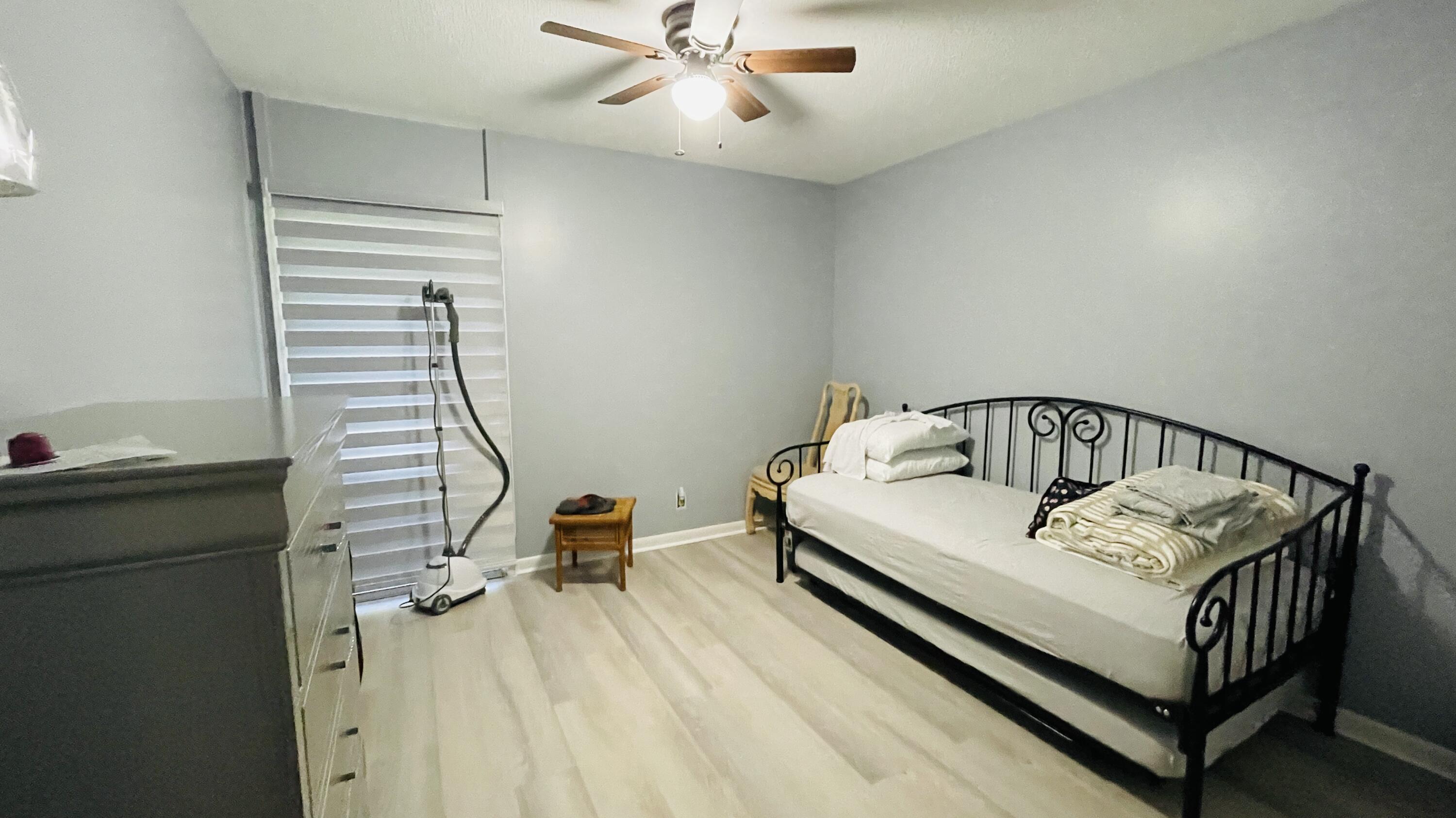 11 Golfs Edge, Unit E West Palm Beach, FL 33417 - Photo 9 of 14 a view of a bedroom with a bed and wooden floor