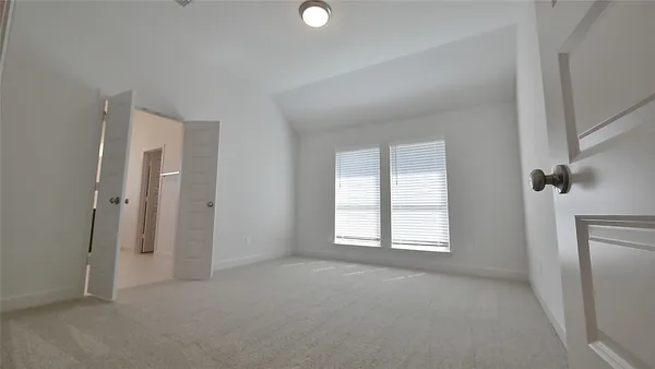 a large bedroom with a bed and a large window