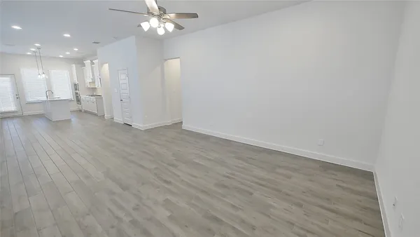 a view of a livingroom with a kitchen counter tops and a ceiling fan