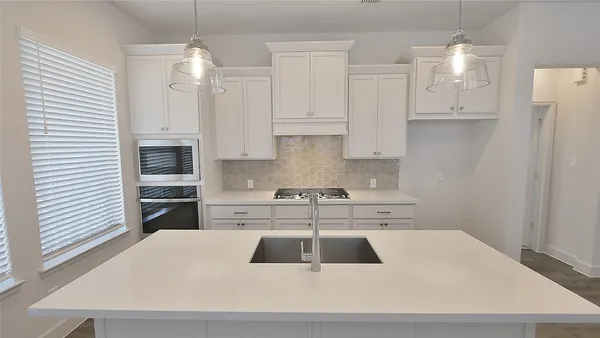 a kitchen with a white cabinets appliances and a fireplace