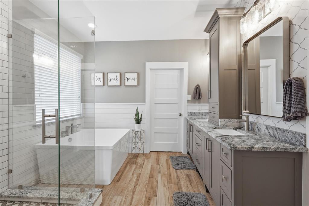 216 Durango Drive Trophy Club, TX 76262 - Photo 18 of 40 Bathroom featuring wood-style flooring, a spacious soaking tub, and a dual vanity with a granite countertop and ample storage