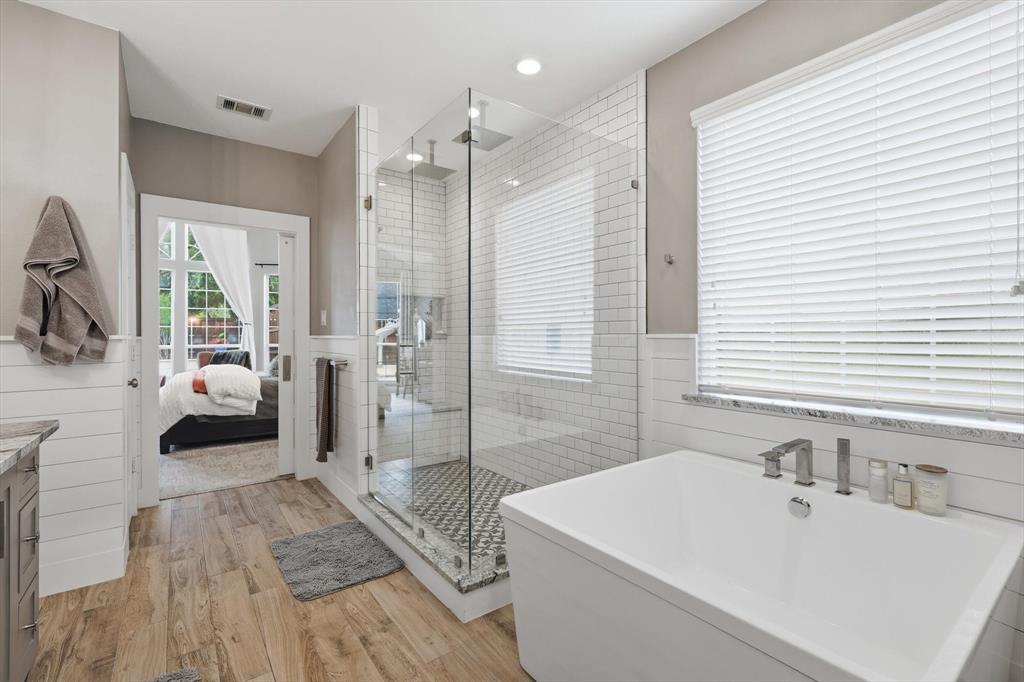 216 Durango Drive Trophy Club, TX 76262 - Photo 20 of 40 The bathroom features wood-look flooring, a glass-enclosed shower with subway tile walls and a mosaic tile floor, and a freestanding soaking tub