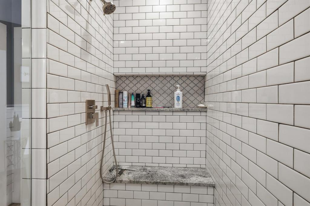 216 Durango Drive Trophy Club, TX 76262 - Photo 21 of 40 The shower features white subway tile, a built-in bench with a granite top, and a recessed niche with decorative arabesque tile