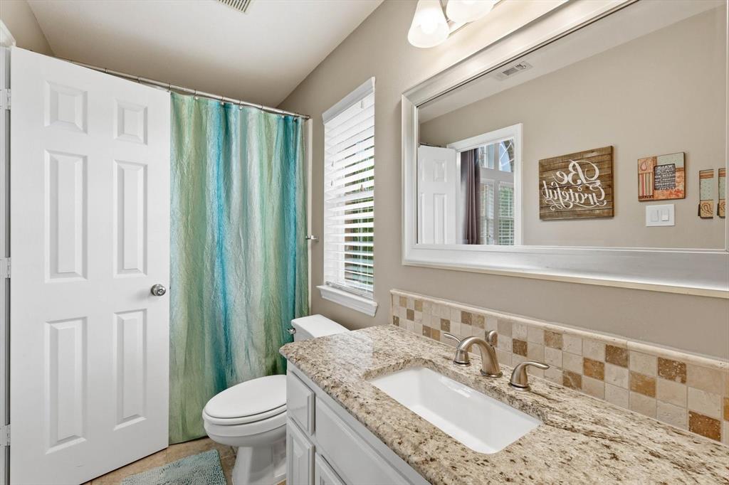 216 Durango Drive Trophy Club, TX 76262 - Photo 25 of 40 Bathroom featuring a vanity with a granite countertop, a built-in sink, and a tiled backsplash