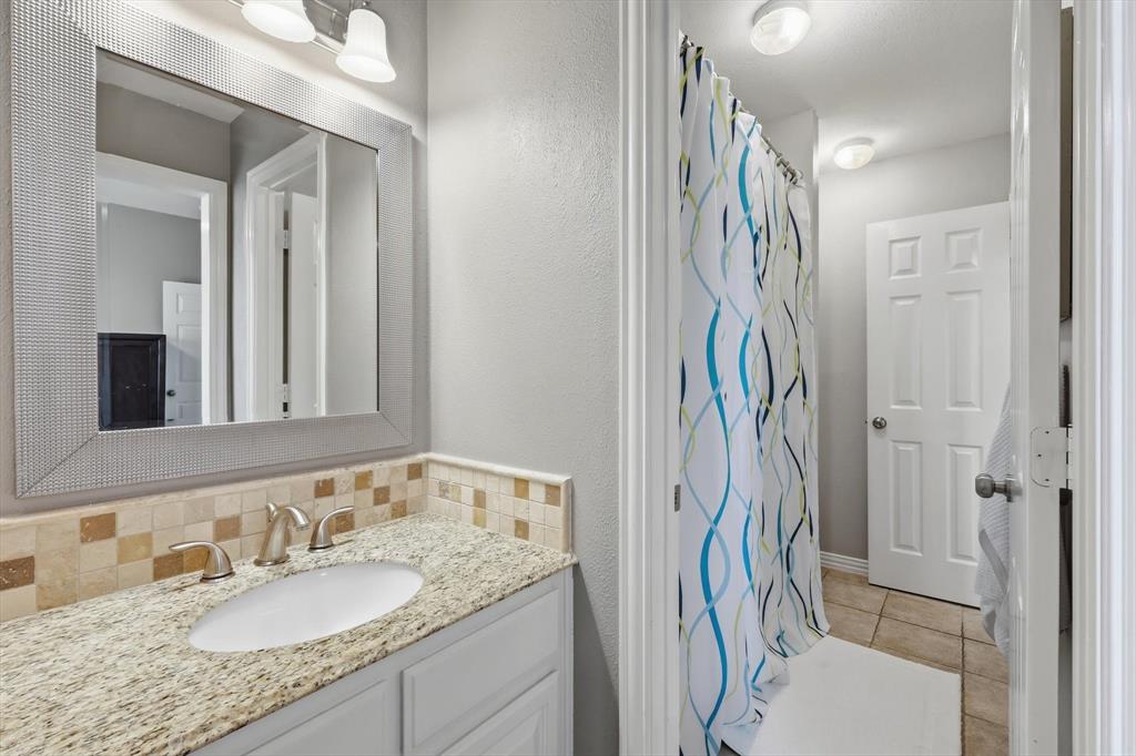 216 Durango Drive Trophy Club, TX 76262 - Photo 28 of 40 Bathroom featuring a vanity with a light-colored countertop, a rectangular mirror, and a tiled shower area