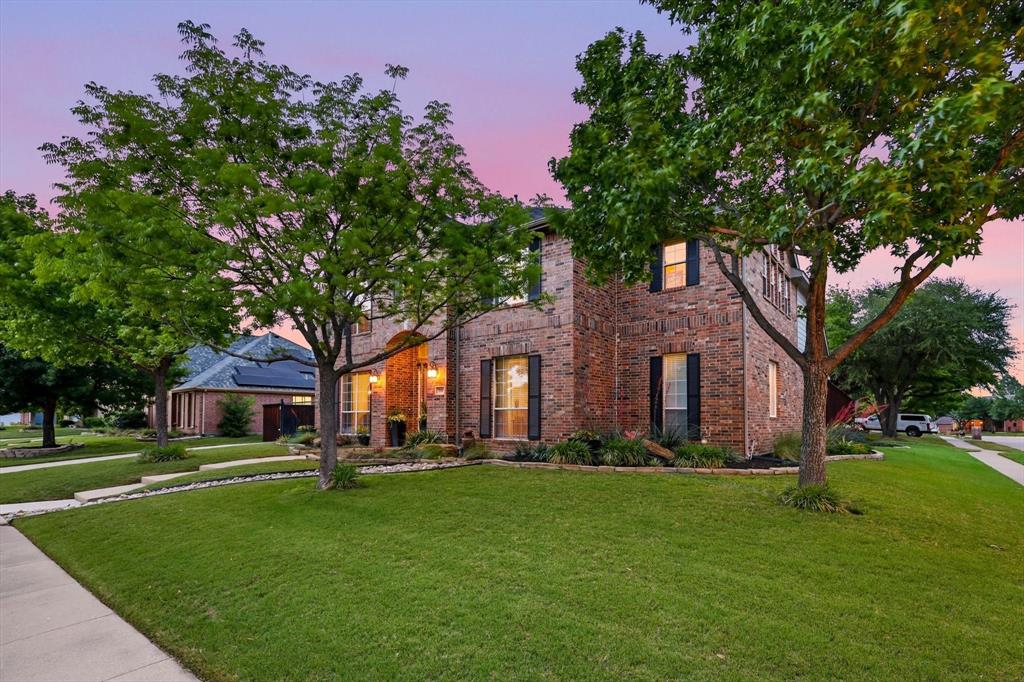 216 Durango Drive Trophy Club, TX 76262 - Photo 3 of 40 This property features a brick exterior, a well-maintained lawn, and mature trees