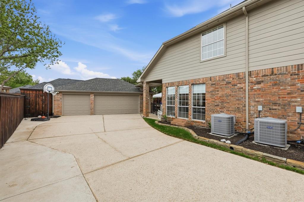 216 Durango Drive Trophy Club, TX 76262 - Photo 34 of 40 The property features an extensive concrete driveway, a two-car garage with tan doors, and a brick and siding exterior