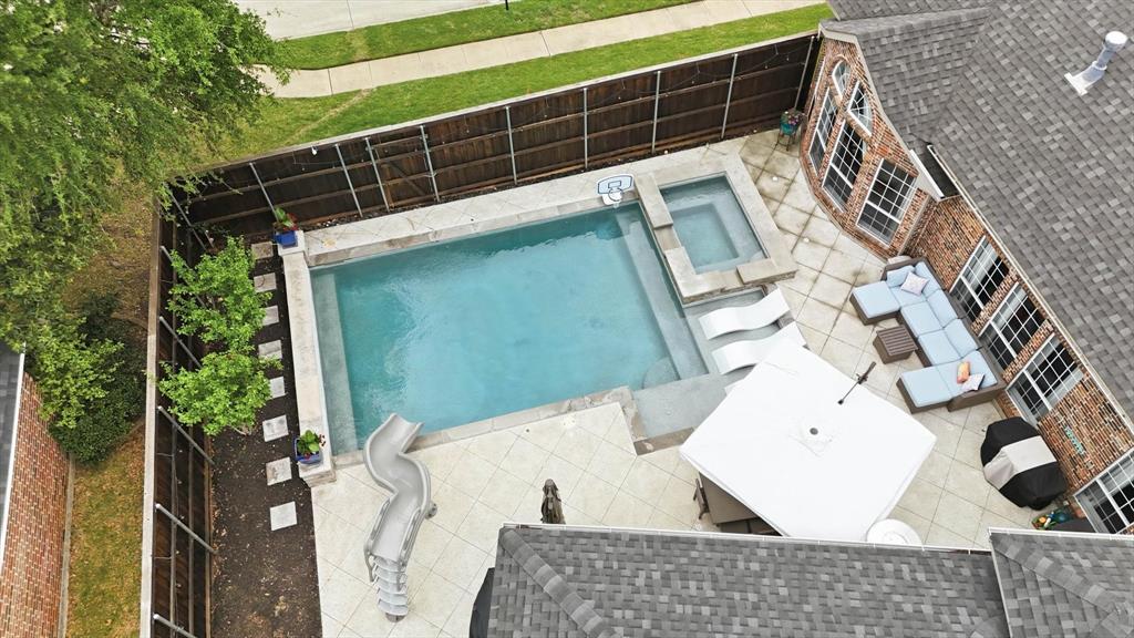 216 Durango Drive Trophy Club, TX 76262 - Photo 39 of 40 The property features a backyard with a swimming pool, an integrated spa, and a paved patio area