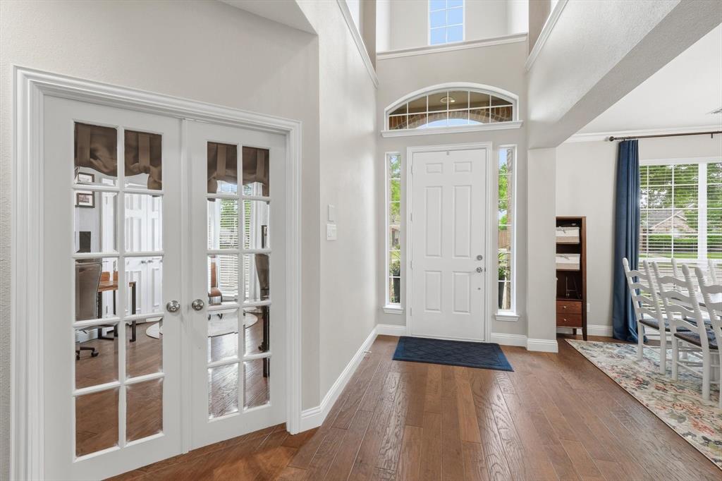 216 Durango Drive Trophy Club, TX 76262 - Photo 4 of 40 The property features hardwood floors, a white front door with sidelights and an arched transom window, and white French doors