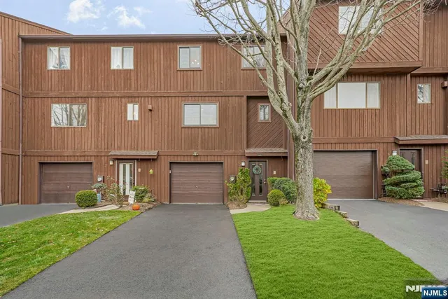a front view of a house with garden and plants