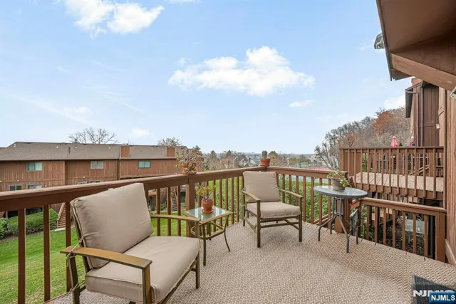 a balcony with wooden floor outdoor seating and city view