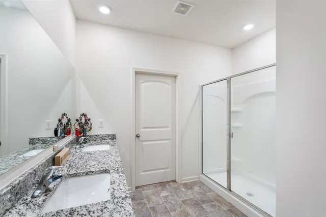 a bathroom with a granite countertop shower sink and mirror