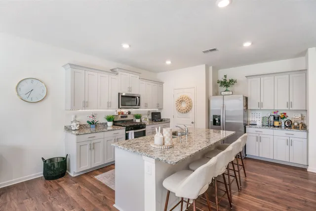 a kitchen with a table chairs stove and cabinets