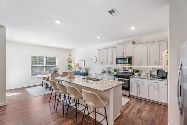 a kitchen with a table chairs and wooden floor