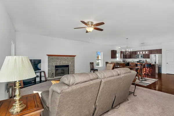a living room with furniture a fireplace and a chandelier