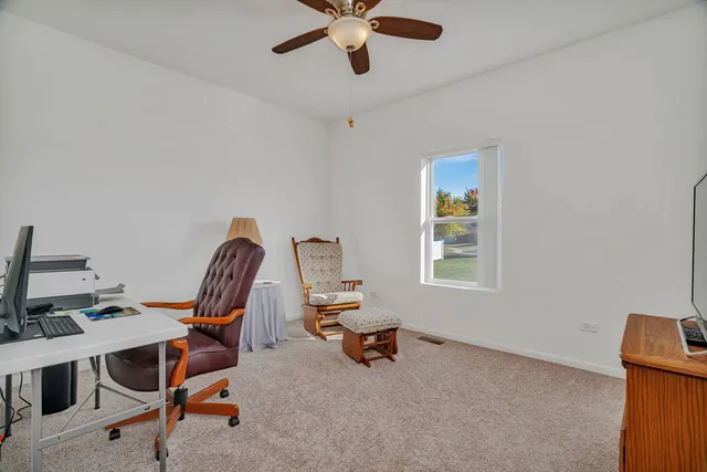 a view of a workspace with furniture and a window