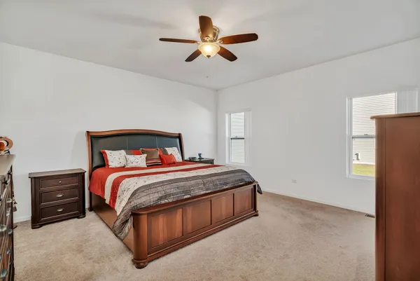 a bedroom with a bed and a ceiling fan