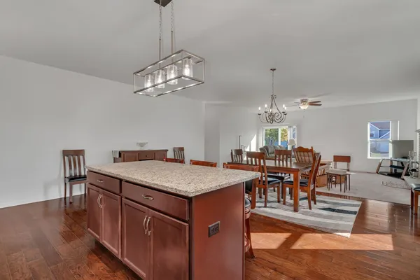 a view of a dining room with furniture a chandelier and wooden floor