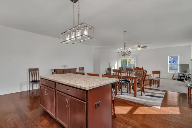 a view of a dining room with furniture a chandelier and wooden floor