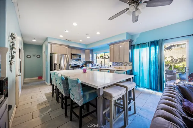 a living room with stainless steel appliances granite countertop furniture a fireplace and a view of kitchen
