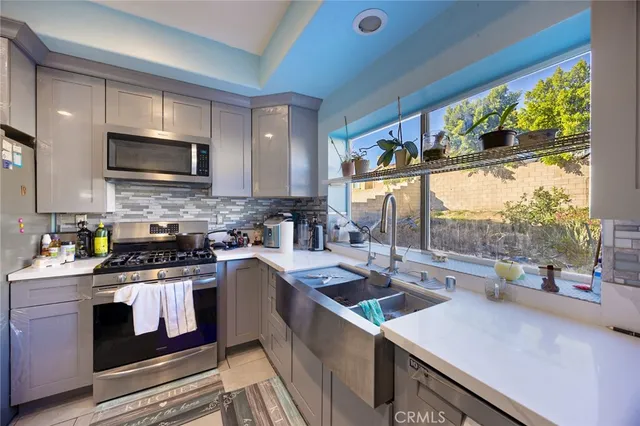 a kitchen with a stove a sink and a microwave