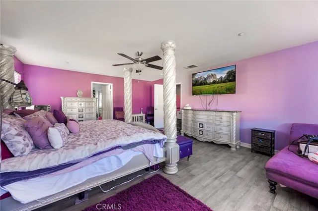 a bedroom with a bed dresser and a flat screen tv