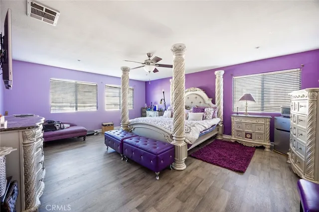 a spacious bedroom with a bed and wooden floor