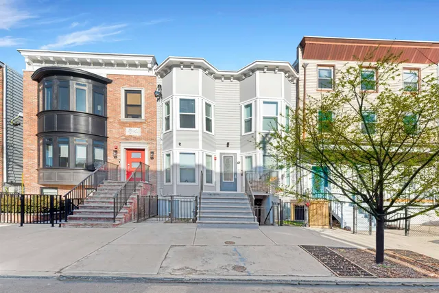 a front view of a residential apartment building with a yard
