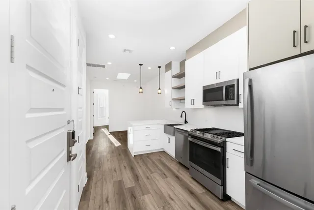 a kitchen with stainless steel appliances a stove a sink and a refrigerator