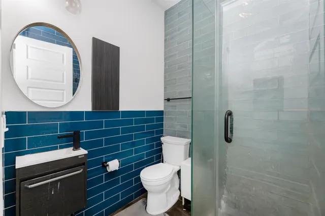 a bathroom with a toilet a sink and mirror