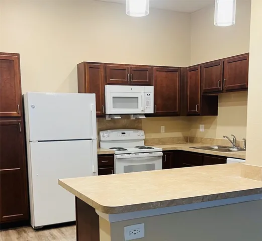 a kitchen with stainless steel appliances a refrigerator a stove a sink and a refrigerator