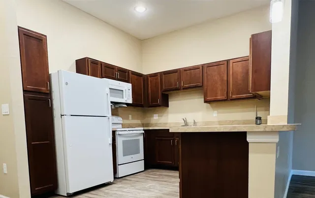 a kitchen with stainless steel appliances granite countertop a refrigerator a stove a sink and a microwave