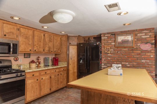 208 West Rader Avenue Ridgecrest, CA 93555 - Photo 4 of 18 a kitchen with stainless steel appliances granite countertop a sink and a stove