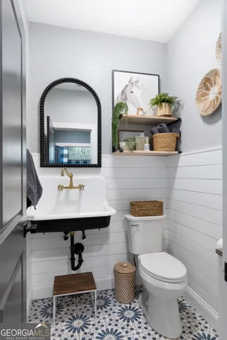 a bathroom with a toilet a sink and mirror