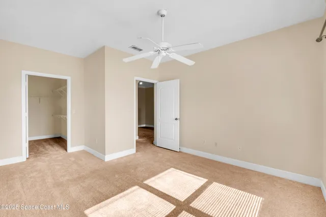 an empty room with fan and a ceiling fan