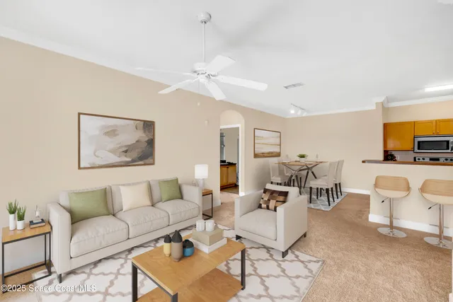 a living room with furniture and a view of kitchen