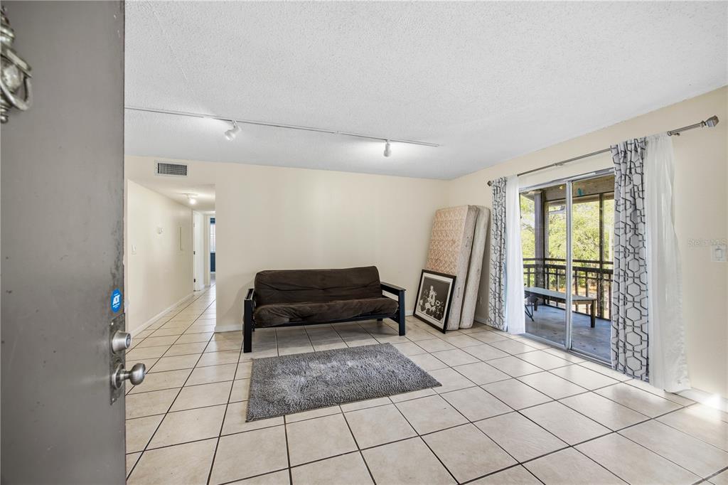 6519 West Newberry Road, Unit 109 Gainesville, FL 32605 - Photo 5 of 21 a living room with a large mirror next to a window