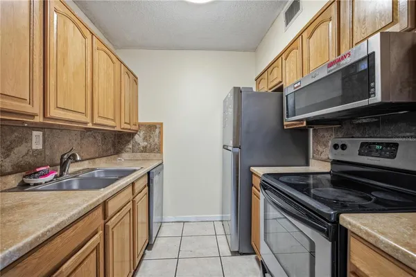 a kitchen with stainless steel appliances granite countertop a stove and a refrigerator