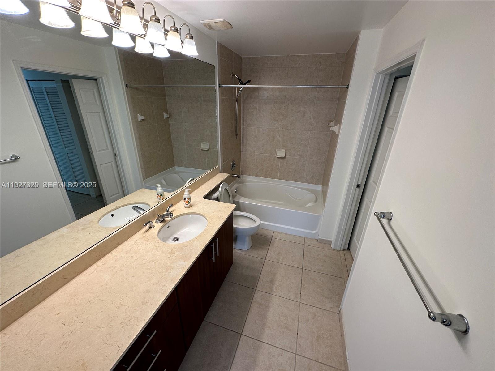 2401 Northeast 65th Street, Unit 606 Fort Lauderdale, FL 33308 - Photo 14 of 19 a bathroom with a sink a large mirror and shower