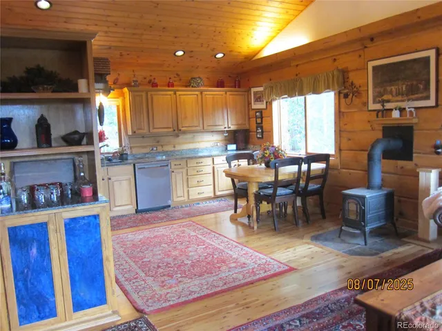 a kitchen with stainless steel appliances granite countertop dining table chairs and a large window