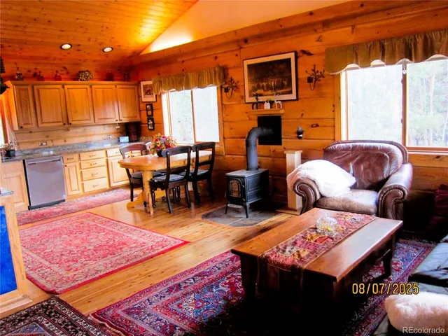 a living room with furniture a rug and a dining table